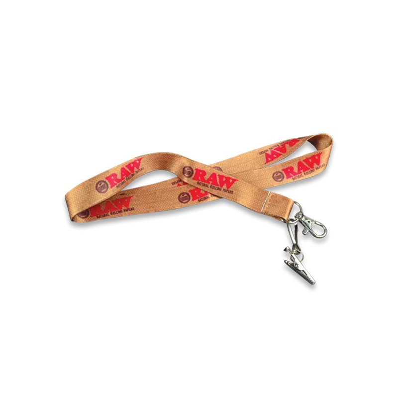 Smycz do kluczy RAW Lanyard w kolorze brązowym z czerwonym logo RAW i metalowymi zaczepami na końcu, pozostałe 
